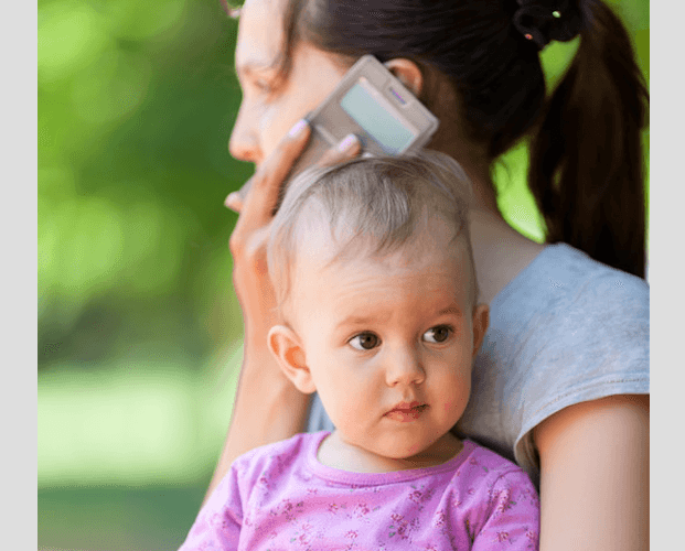 Mom on phone holding child